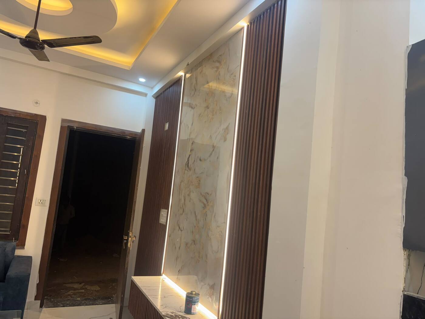 Marble-finish TV wall with lit wooden slats